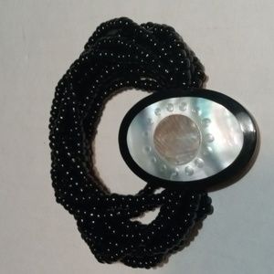 Beaded bracelet with shell colored large emblem. (Sku 114).